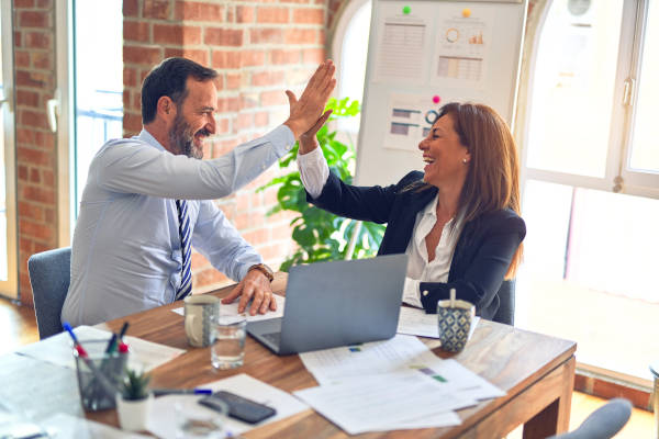 Man and woman high-five over work